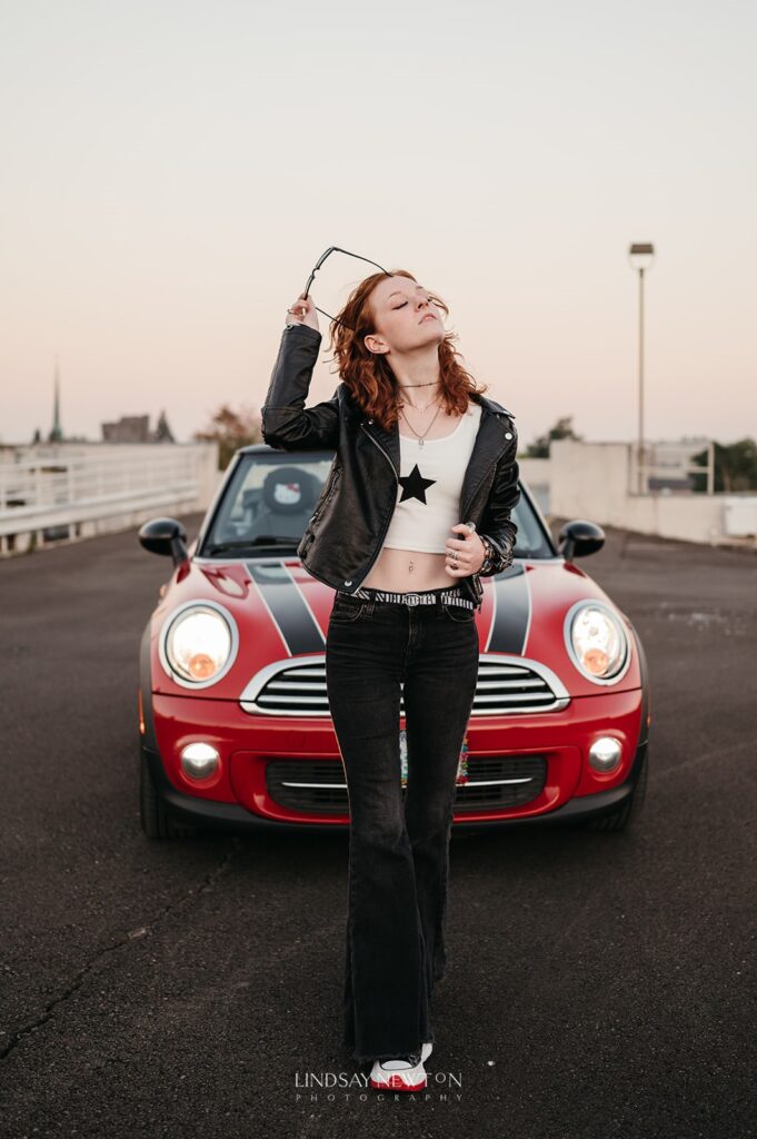senior girl walking in front of her car during her senior photography experience