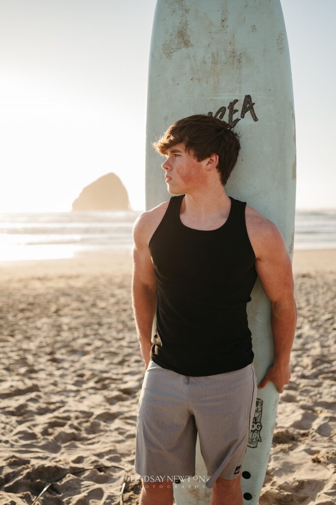 senior guy holding his surf board during his senior photography experience