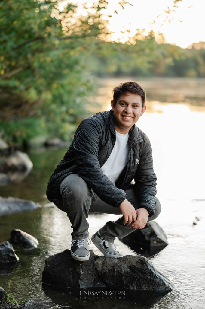 senior guy posing by a river