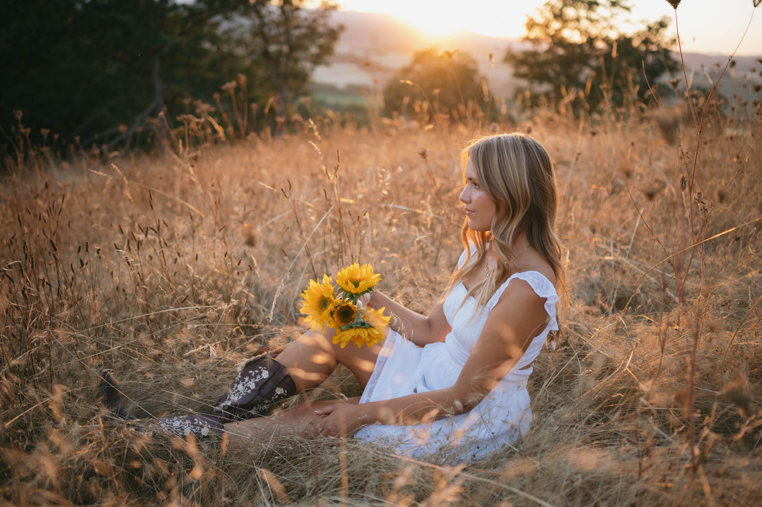 high school senior girl sitting in a grassy field at basket slough