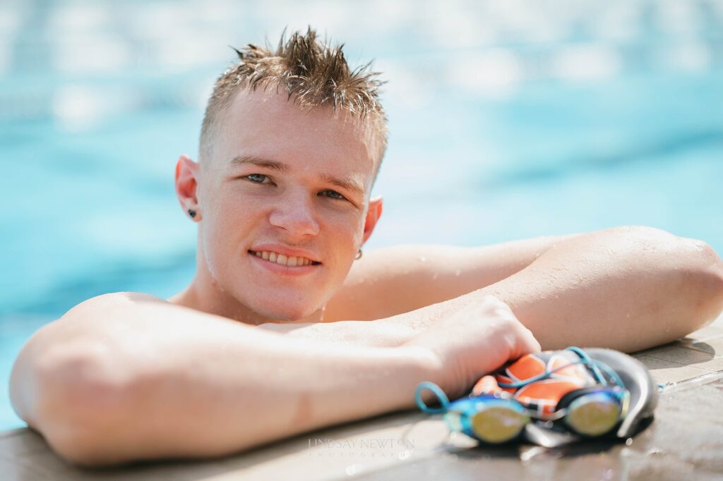 high school senior guy in the Silverton pool, holding his goggles.