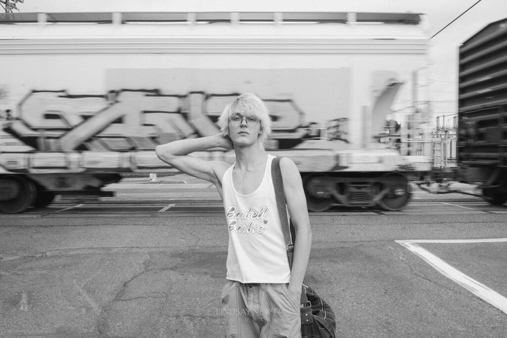 high school senior guy standing in front of a train for his senior session in Portland, Oregon