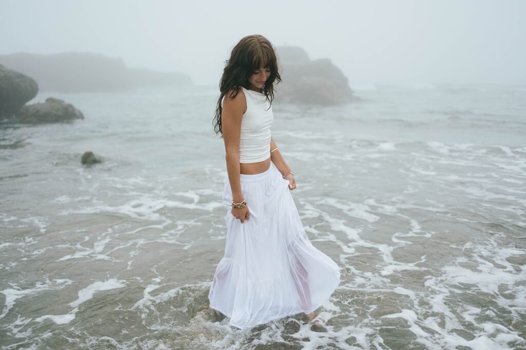 senior photo of a girl walking in the water at her oregon beach senior session. 