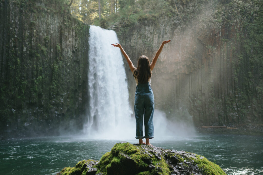 Abiqua Falls senior session with glowing sunlight and cascading waterfall
